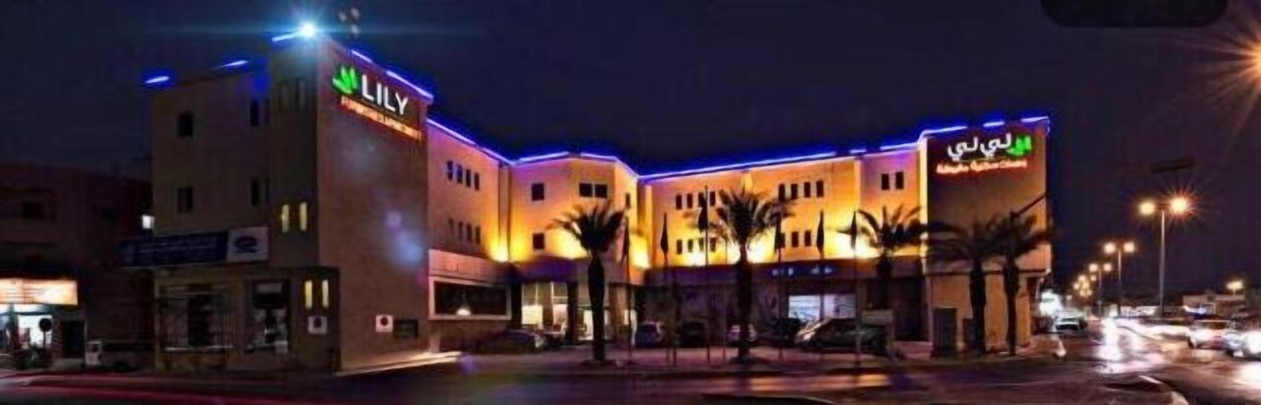 A hotel with a prominent 'Lily' sign, a covered outdoor area, and a parking lot.