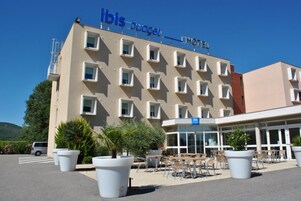 Un hotel con fachada moderna, varios balcones y zonas de estar al aire libre.