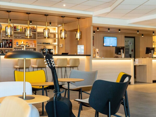 A modern interior with a bar area, seating, and a guitar.
