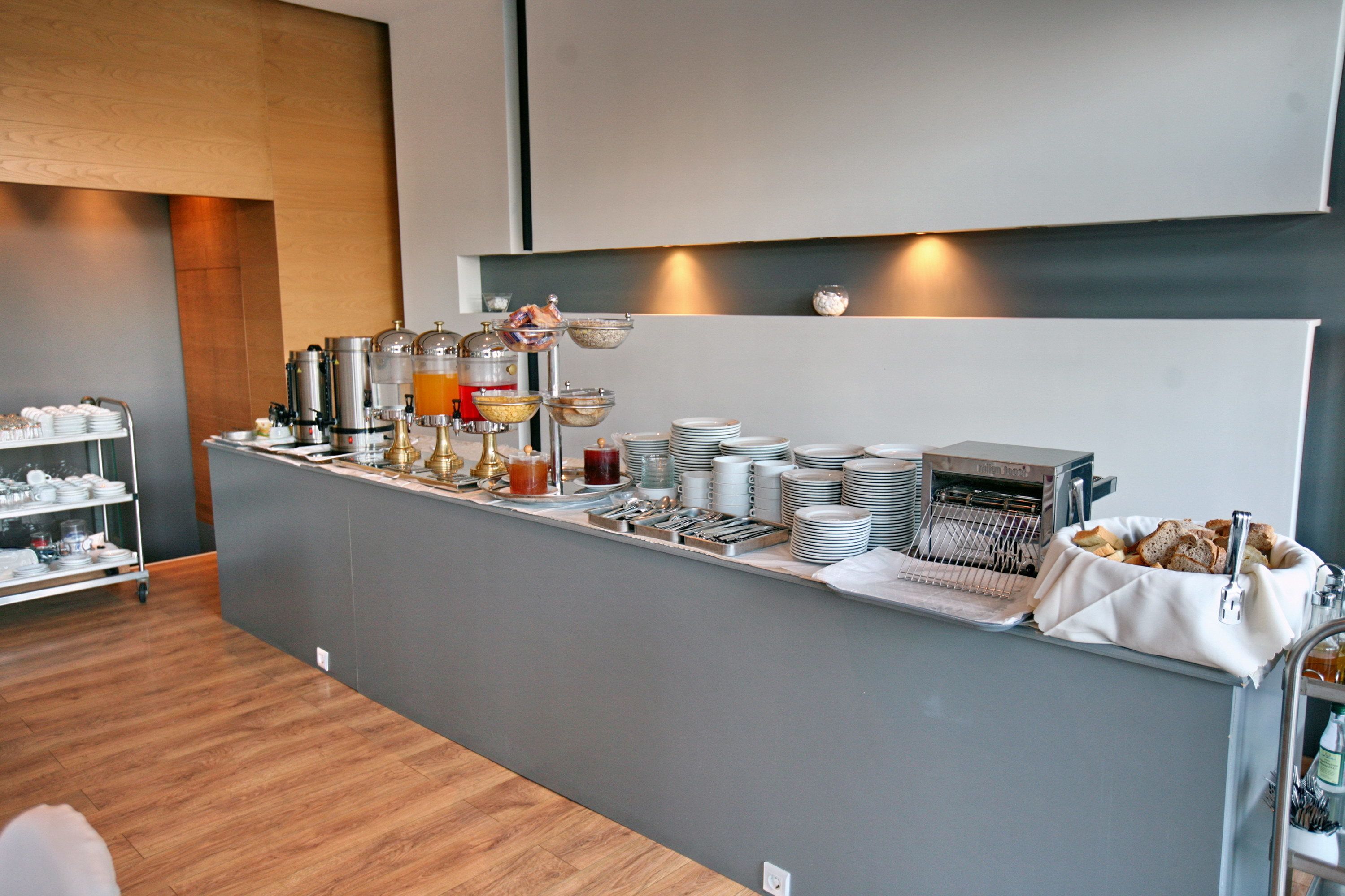 A buffet setup with various food and drink options, including a coffee station and a bread basket.
