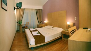 Une chambre d’hôtel comprenant un lit, des tables de chevet, un bureau et une chaise.