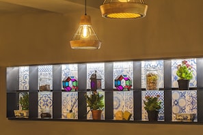 A wall with a series of shelves displaying potted plants and decorative items.