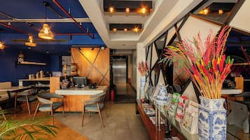 L’intérieur d’un restaurant, avec un comptoir, des chaises et des vases décoratifs.