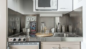Une cuisine compacte équipée d’un four à micro-ondes, d’une cuisinière, d’un évier et d’une pancarte sur le thème de la vie.