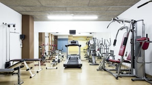 A gym with various exercise equipment, including treadmills, weight machines, and benches. - Residencia Universitaria Resa Campus de Montilivi (Girona)