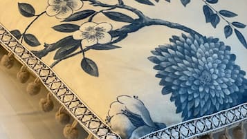 A pillow with a floral design and a fringe border.