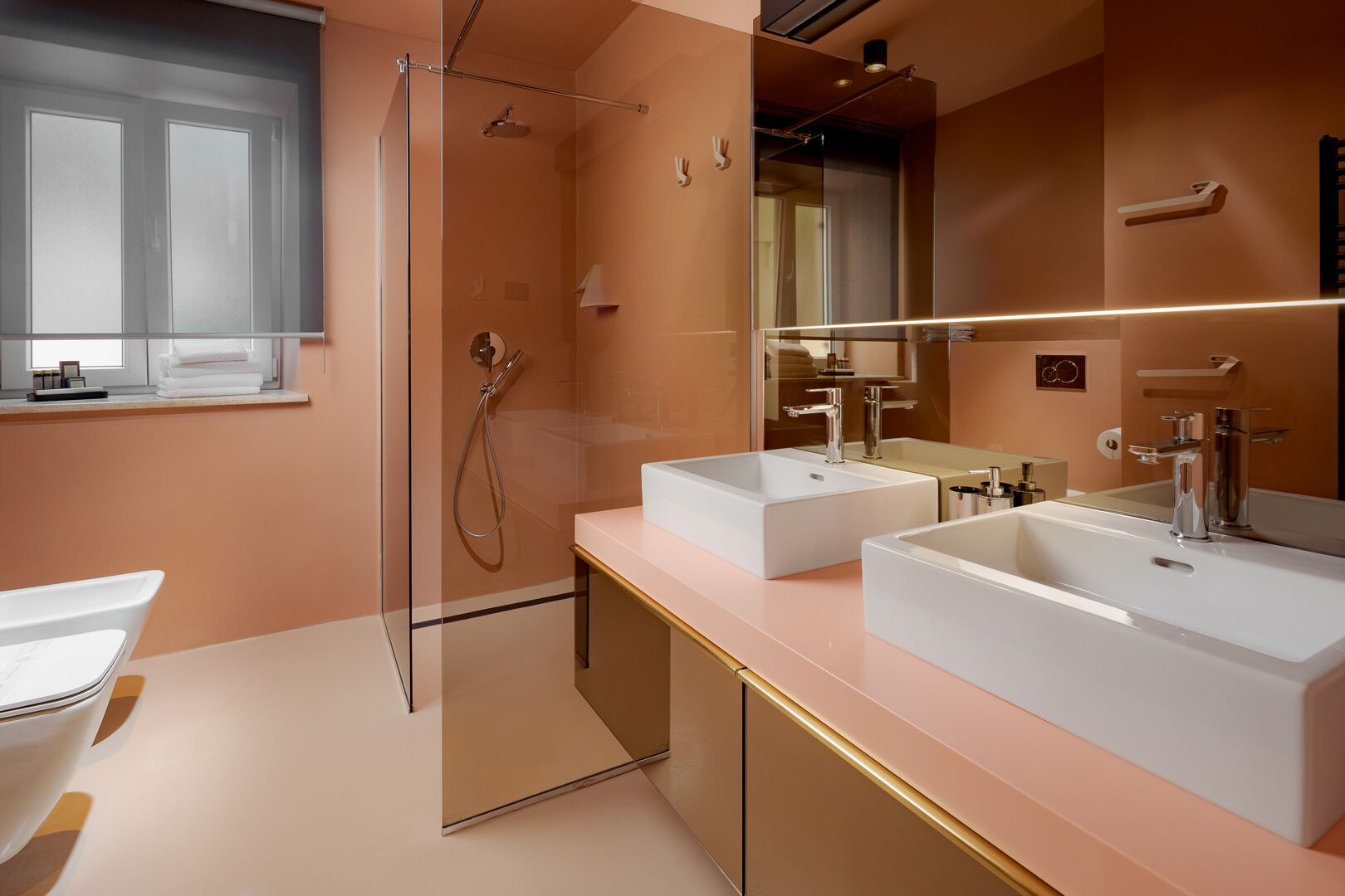 Een moderne badkamer met twee wasbakken, een douche en een grote spiegel.