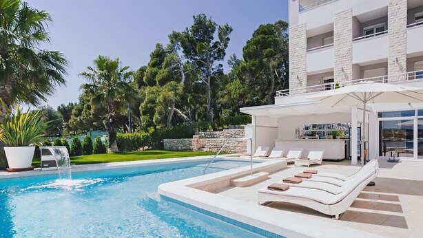 A modern pool area with lounge chairs and a bar. - Ribarska Koliba Resort (Pula)