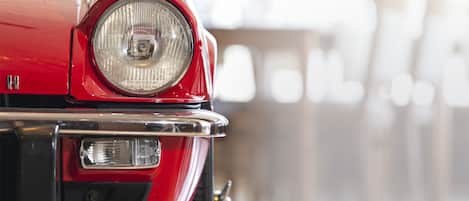 A close-up of a vintage car's headlight and bumper.