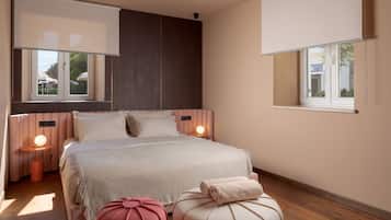 A modern bedroom with a large bed, bedside lamps, a window, and a view of the outdoors.