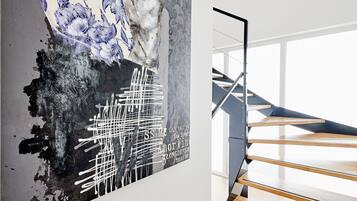 A modern staircase with wooden steps and metal railings, leading to an upper floor.