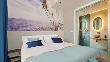 Habitación de hotel moderna con una cama grande, un baño con paredes de vidrio y un mural panorámico en la pared.