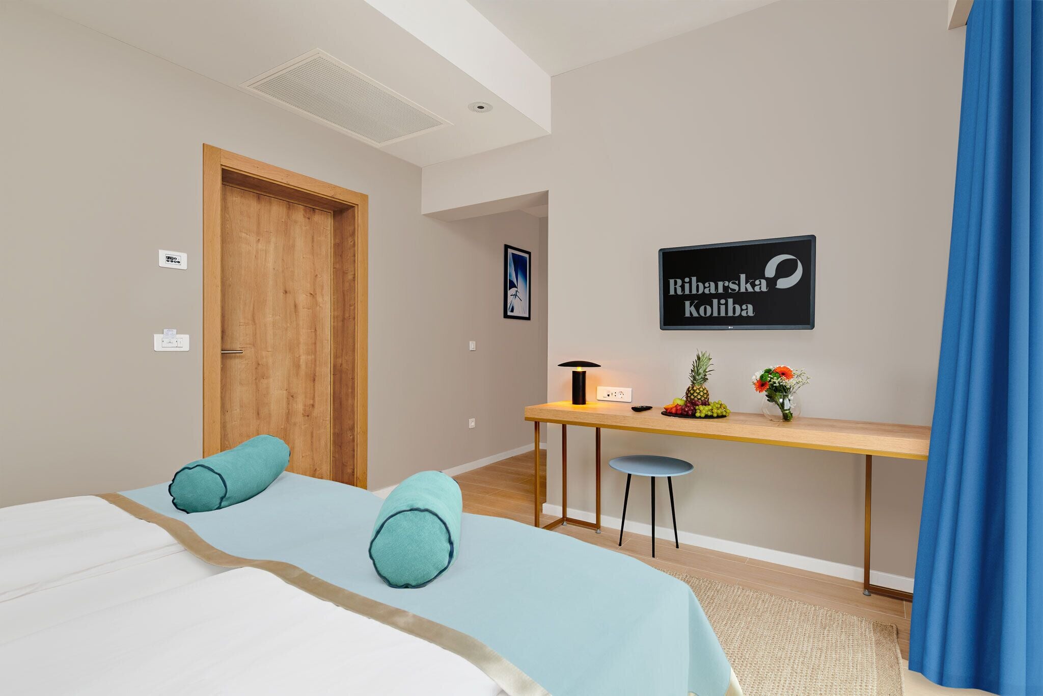 Een hotelkamer met een bed, een bureau, een stoel en een bord aan de muur.