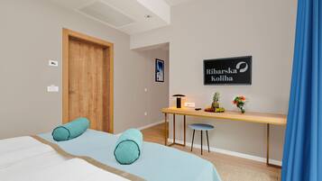 Una habitación de hotel con cama, escritorio, silla y un cartel en la pared.