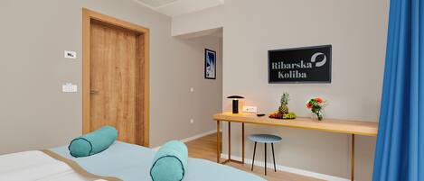 Een hotelkamer met een bed, een bureau, een stoel en een bord aan de muur.