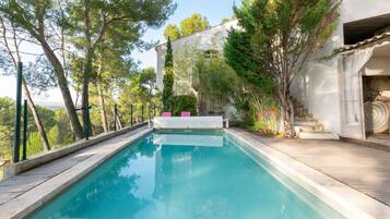 Piscina a l'aire lliure, para-sols i gandules