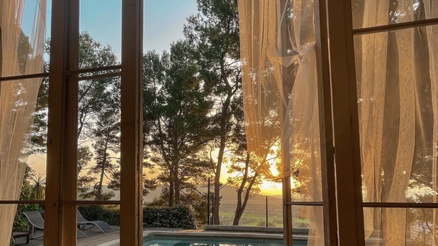 A view from a room with large windows overlooking a pool area. - Le Mas des Roches (Velaux)