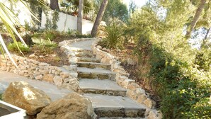 A stone staircase leading up a hill, surrounded by greenery and trees. - Le Mas des Roches (Velaux)