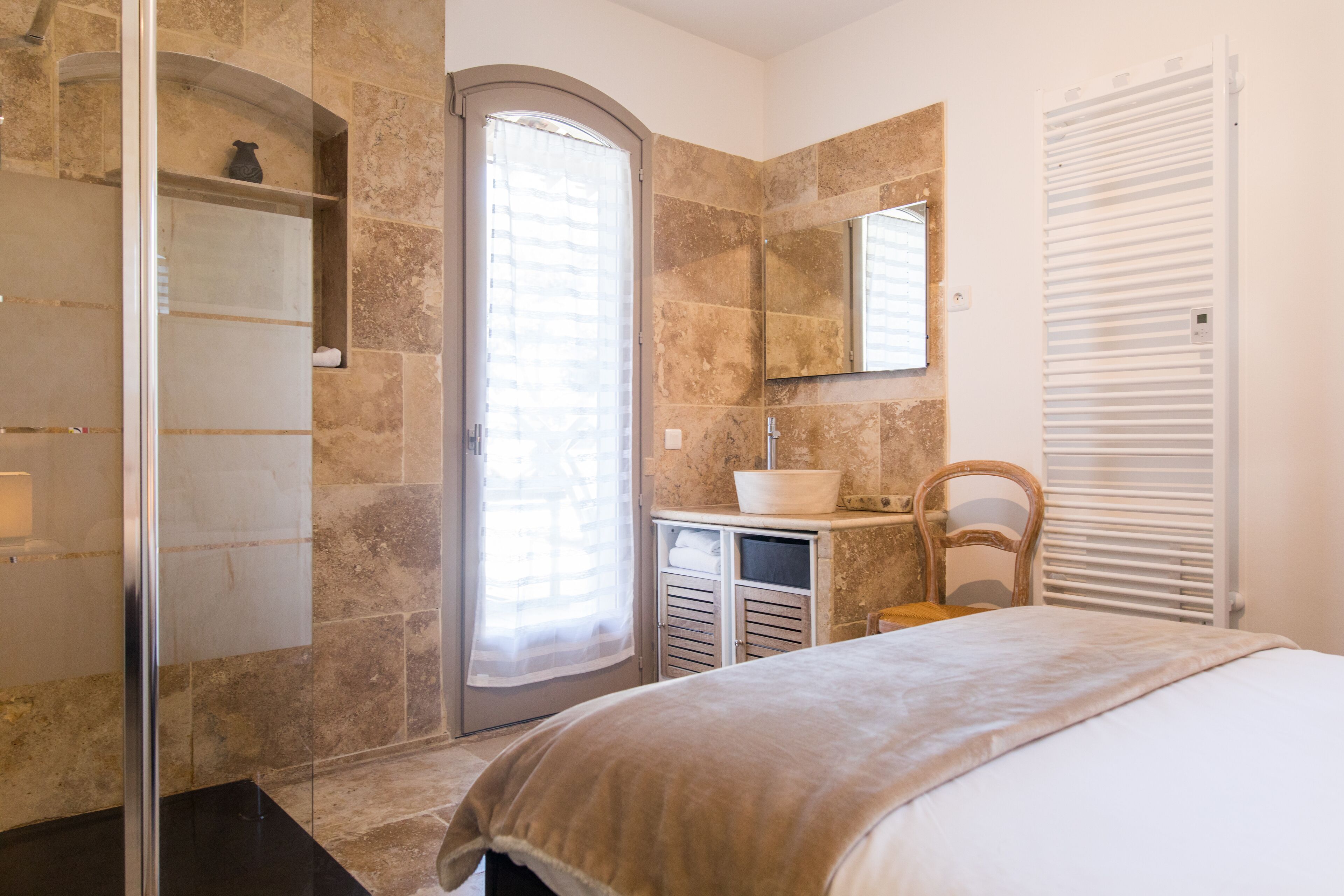 A modern bathroom with a shower, a sink, and a mirror.