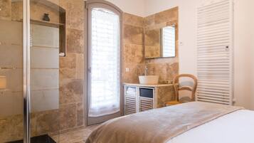 Une salle de bain moderne avec une douche, un lavabo et un miroir.