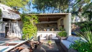 A patio with wicker furniture, a small table, and a potted plant. - Le Mas des Roches (Velaux)