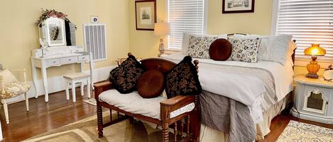 Une chambre à coucher comprenant un lit, une table de chevet, une lampe, une commode, un miroir et une chaise.