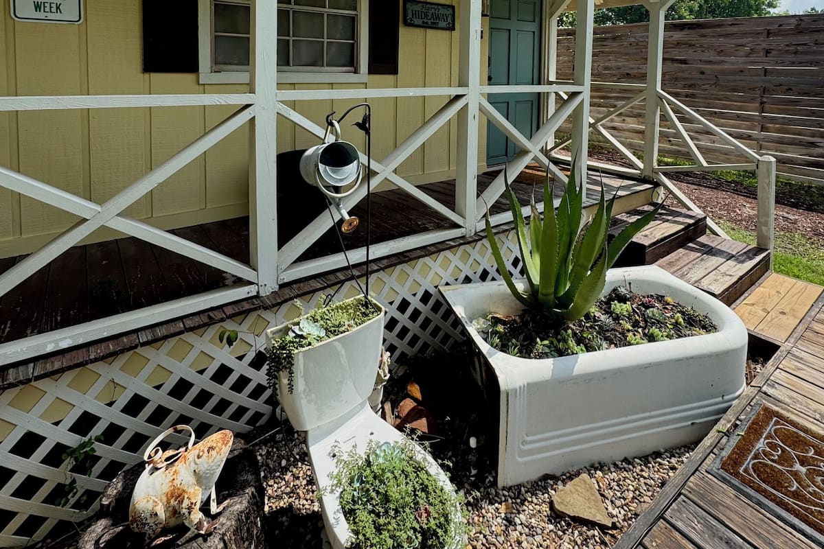 A building with a porch, a 'HIDEAWAY' sign, and a 'RESERVED FOR EMPLOYEE OF THE WEEK' sign.