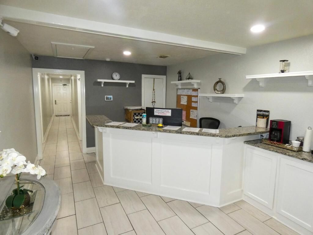 A reception area with a counter, a clock, and a bulletin board.