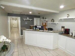 A reception area with a counter, a clock, and a bulletin board.