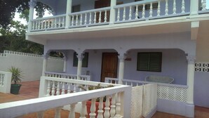 A two-story building with a white balcony and a wooden door. - Ocho Rios Tamarind Villas (Ocho Rios)