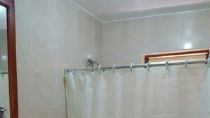 A small bathroom with a toilet, sink, and shower curtain. - Ocho Rios Cinnamon Villas (Ocho Rios)