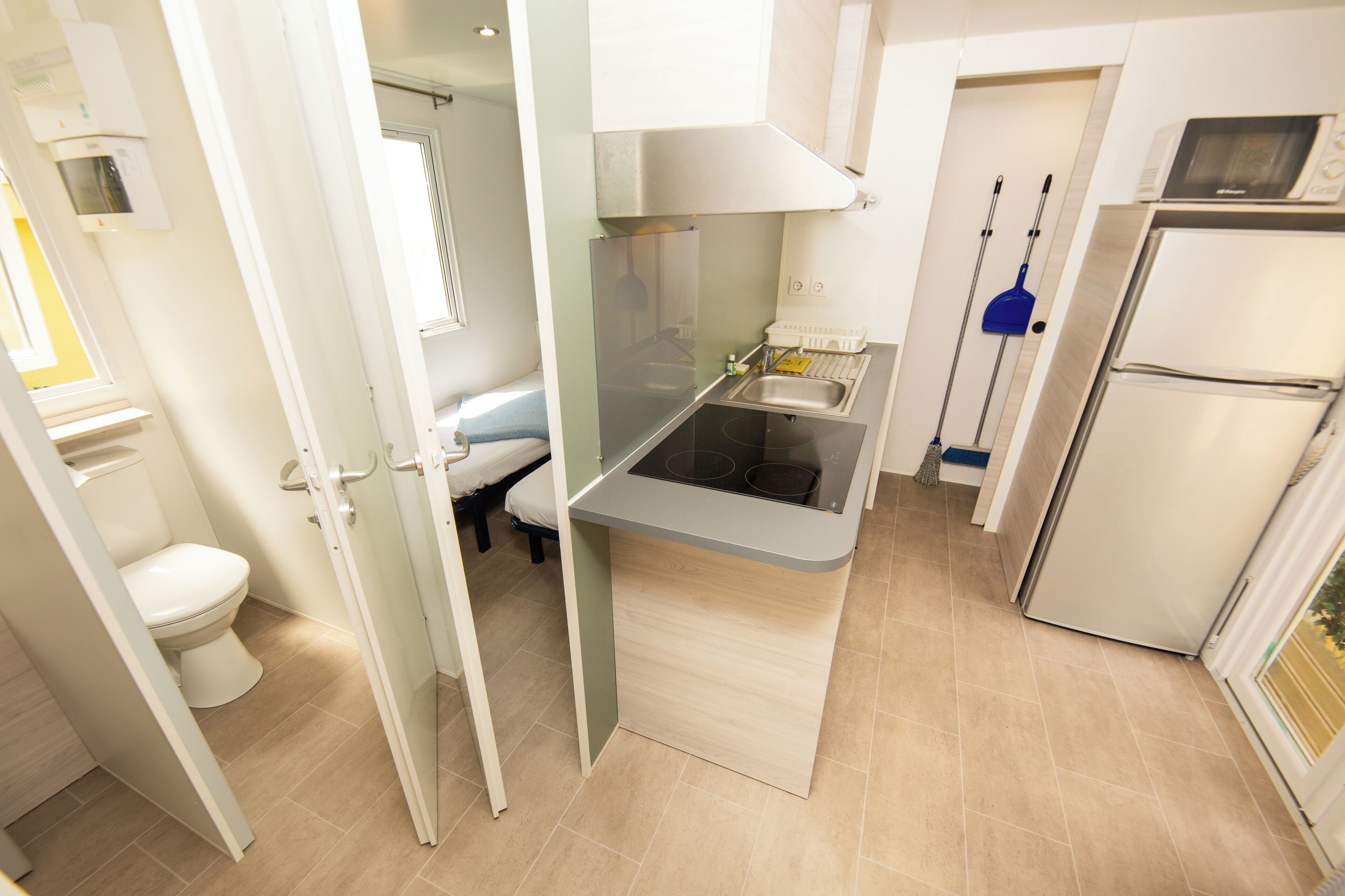 A compact kitchen with a built-in microwave, a sink, and a refrigerator.