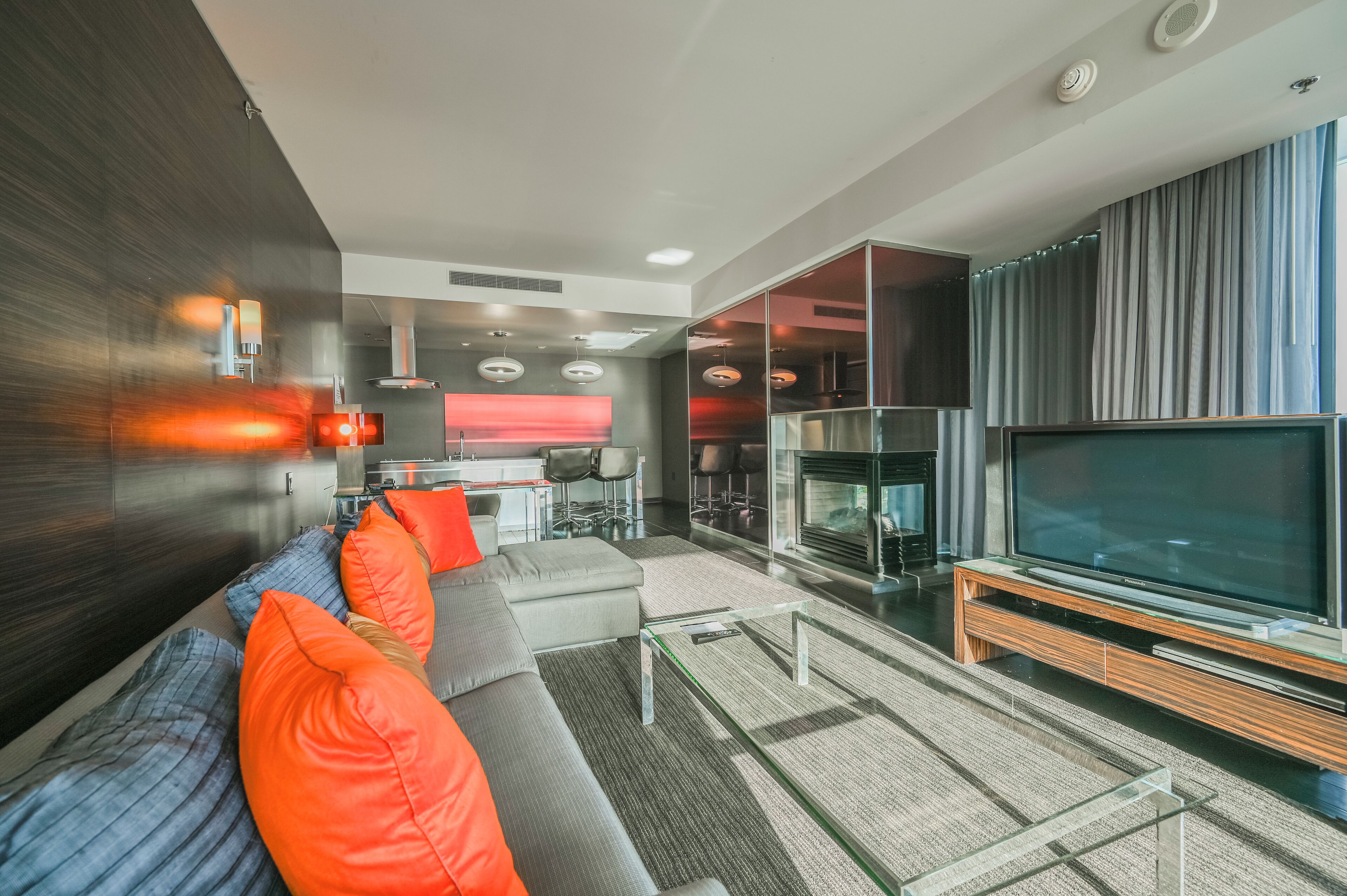 A modern living room with a sofa, TV, and fireplace.