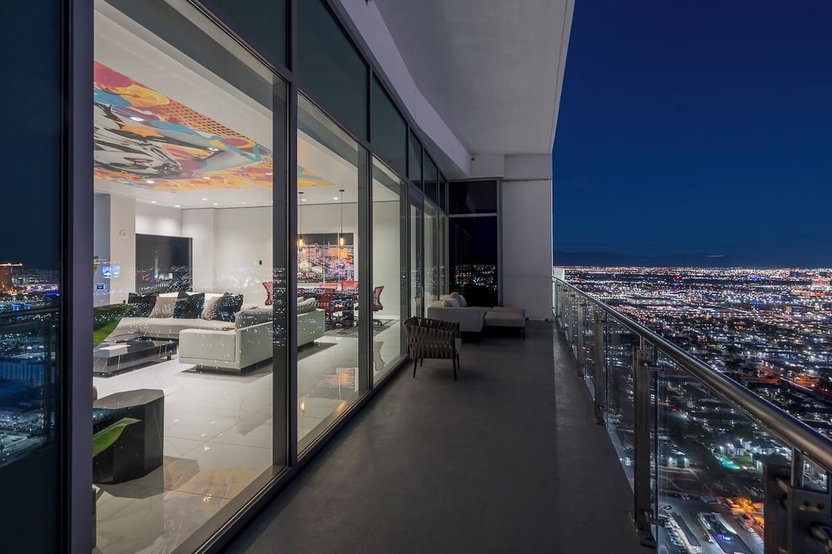 Un salon moderne avec vue sur la ville, de grandes fenêtres et un mobilier contemporain.