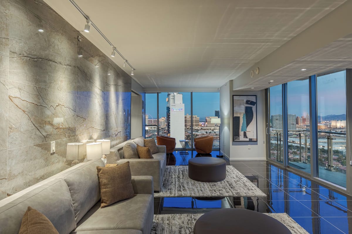 Un espace de détente moderne offrant une vue sur la ville, avec des murs en marbre et un mobilier contemporain.