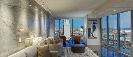 A modern lounge area with a city view, marble walls, and contemporary furniture.