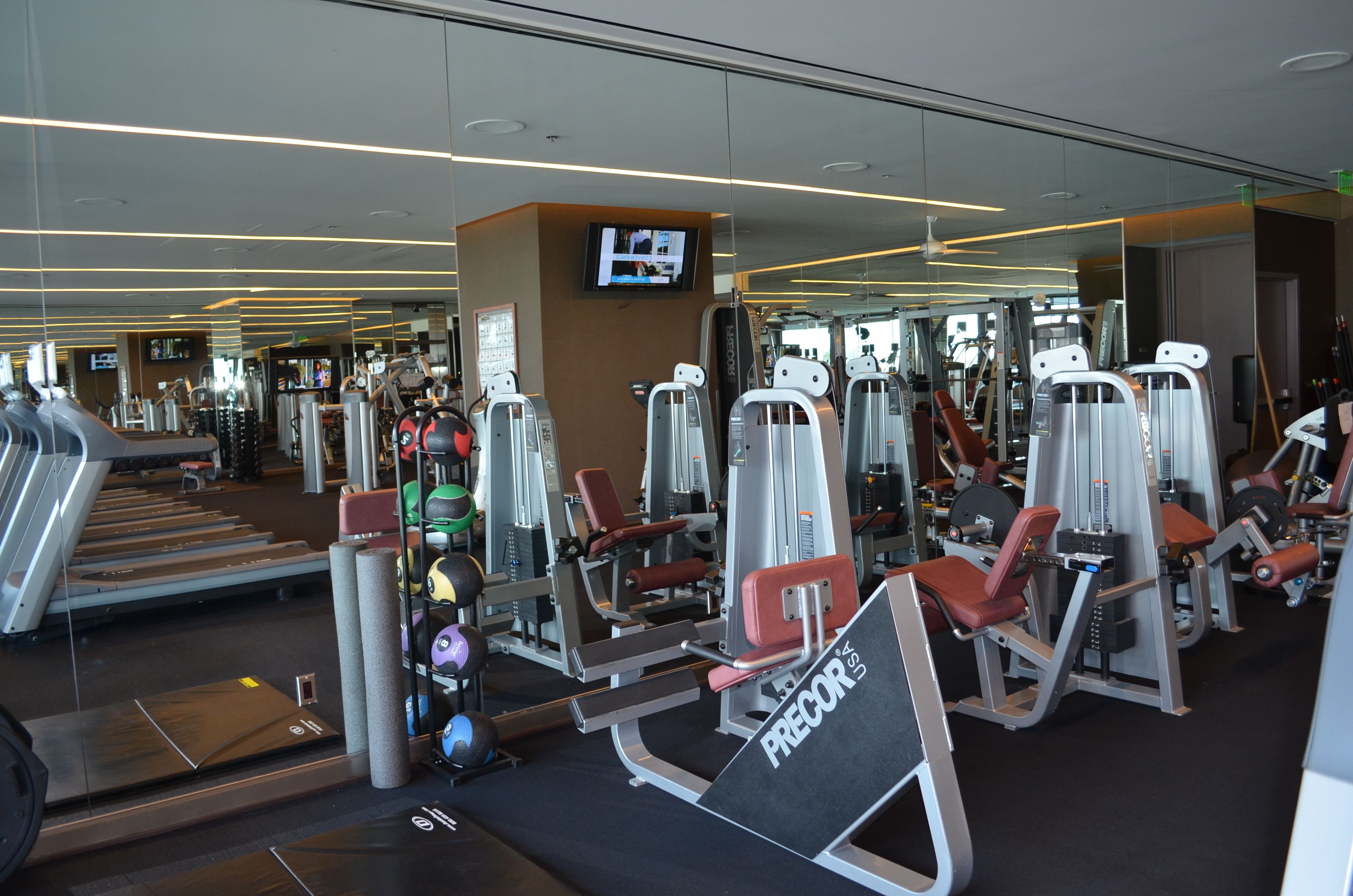 A gym with various exercise machines, treadmills, and weights.