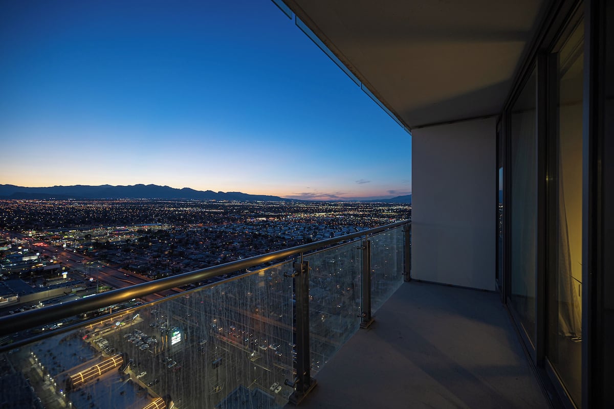 Un balcon donnant sur la ville, au crépuscule.
