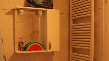 Un bagno con lavandino, specchio e porta asciugamani.