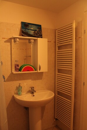 Ein Badezimmer mit Waschbecken, Spiegel und Handtuchhalter.
