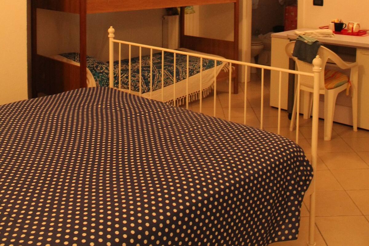 Une chambre avec des lits superposés, un bureau et une chaise.