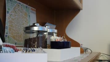 Una scrivania con barattoli di chicchi di caffè, una mappa e una ciotola blu.