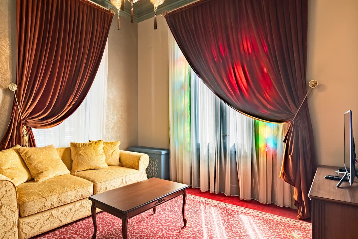 Ein Zimmer mit einer Couch, einem Couchtisch und Vorhängen.