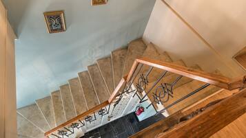 A spiral staircase with wooden railings and a black marble floor.