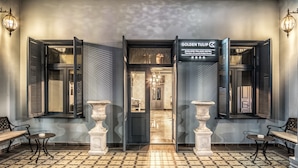 Entrada de hotel con un mostrador de recepción, un área de atención al cliente y piso de baldosas.