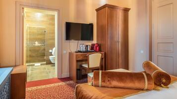A hotel room with a bed, a desk, a television, and a wardrobe.