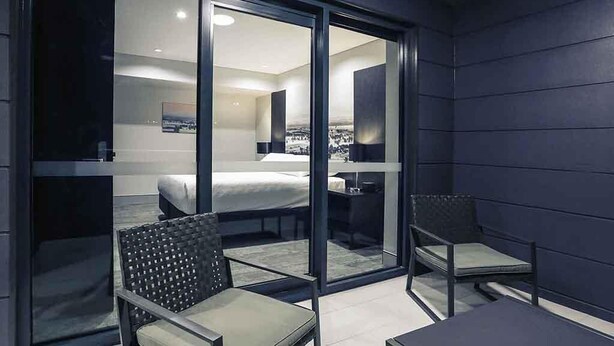 A modern hotel room with a bed, a desk, and a chair. - Mercure Tamworth (West Tamworth)