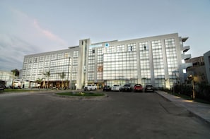 A modern hotel with a large parking lot and several cars parked in front. - Casa Andina Select Moquegua (Moquegua)