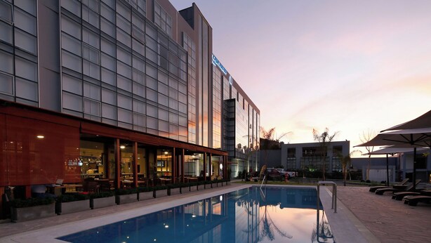 Un hotel moderno con piscina, terraza y restaurante.