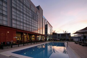 Un hotel moderno con piscina, terraza y restaurante.